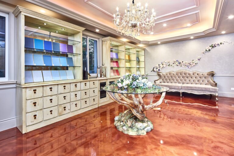 A luxurious showroom displays color swatches, a tufted sofa, and a floral arrangement on a glass table.