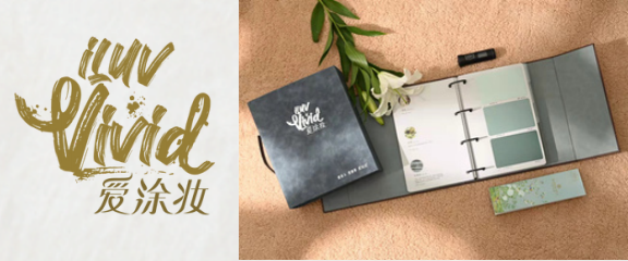 A swatch book with paint samples and a lily rests on a textured surface next to a logo.