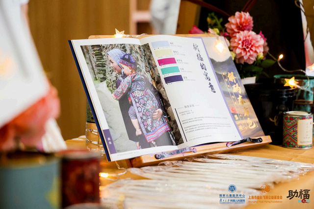 An open book displays a mother and child in traditional clothing, with color swatches and text.