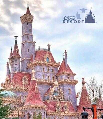 A grand purple castle with red roofs stands under a cloudy sky at Tokyo Disney Resort.