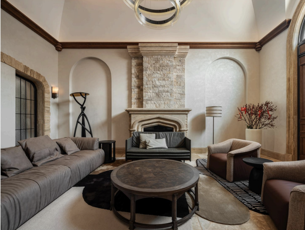 A spacious living room features a large sectional sofa, stone fireplace, and modern seating.