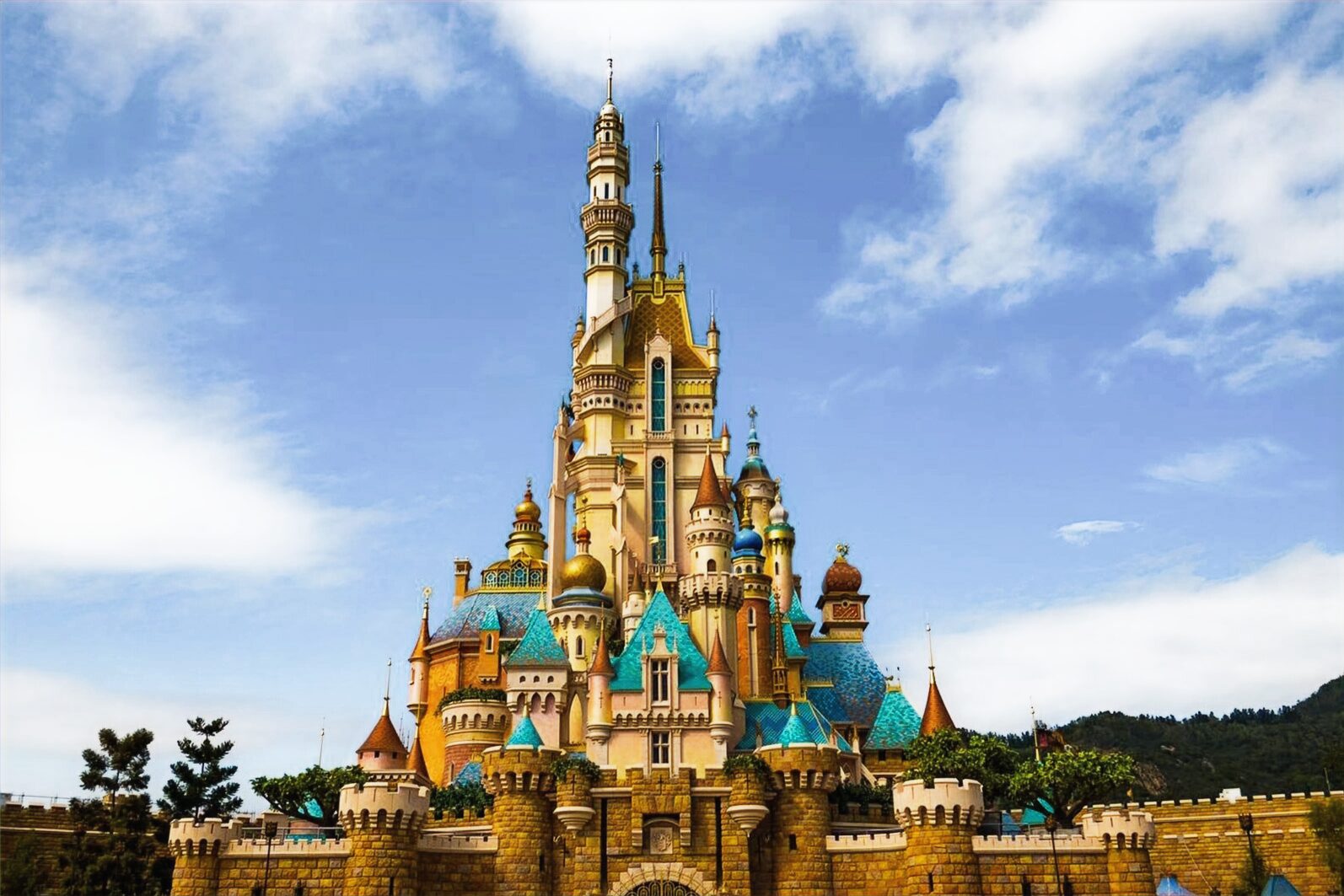 A colorful, ornate castle stands tall against a bright blue sky with fluffy clouds.