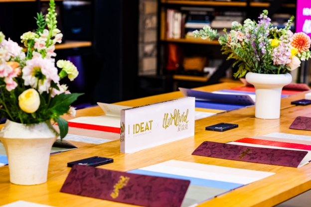 Floral arrangements and place settings adorn a wooden table at a formal event.