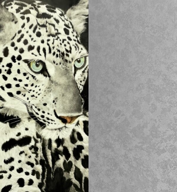 Close-up of a black and white leopard's face with striking green eyes and distinctive spots.