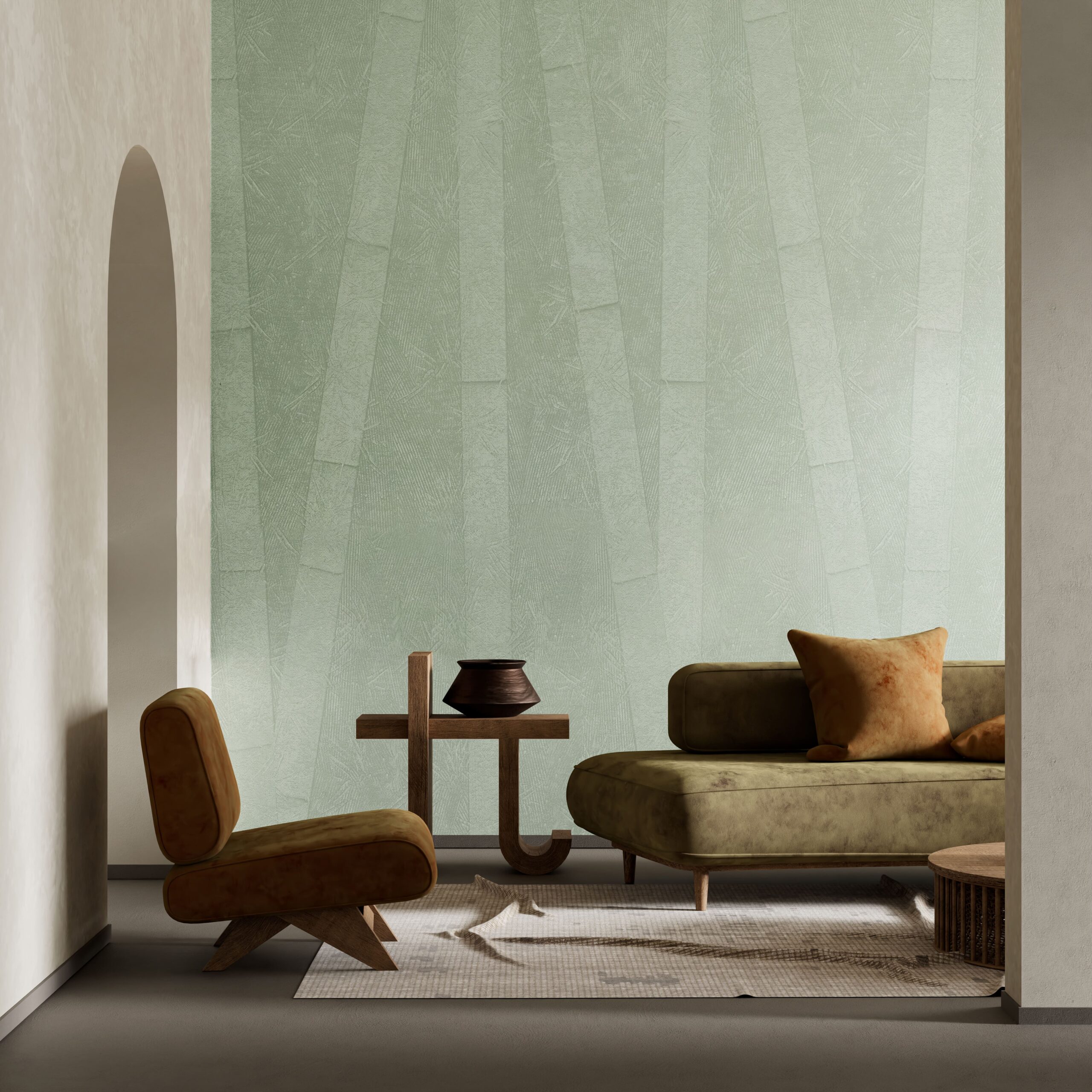 A modern living room features a green textured wall, a brown armchair, and a green sofa with an orange pillow.