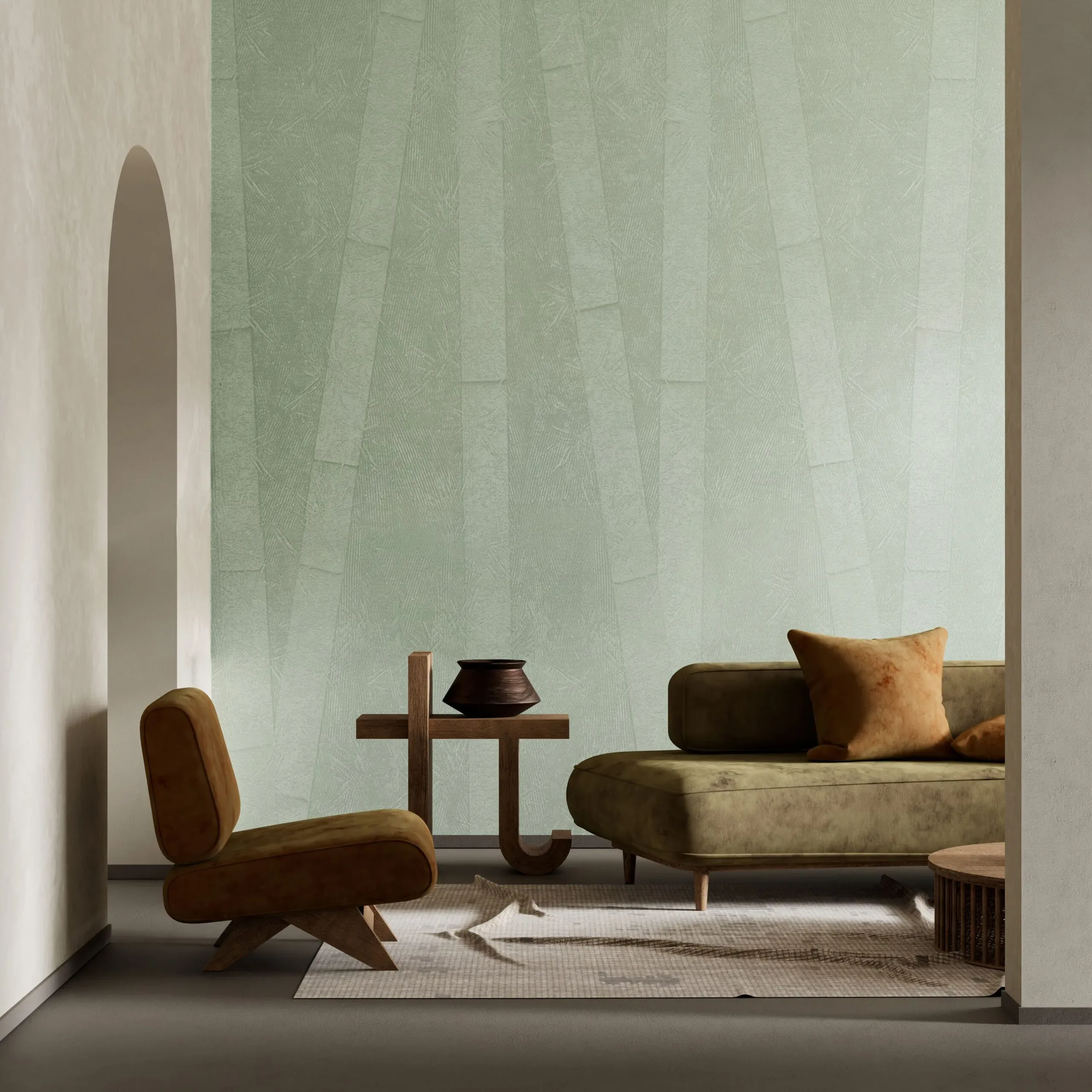 A modern living room features a green textured wall, a brown armchair, and a green sofa with an orange pillow.
