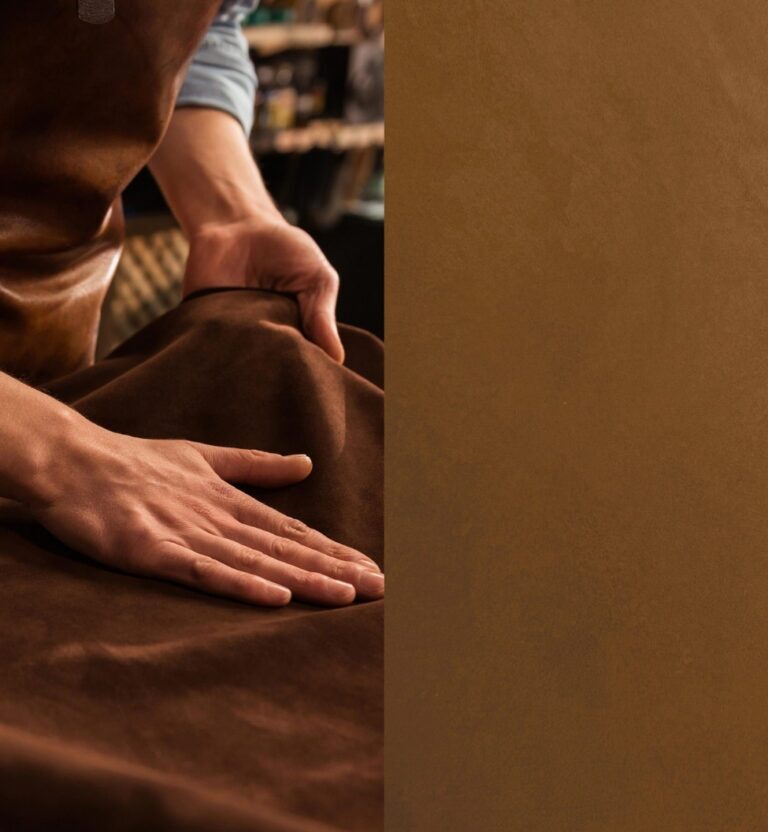 Hands smooth a rich brown suede fabric, suggesting a craftsman's touch.