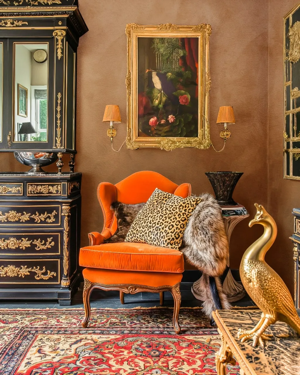 An ornate room features an orange velvet chair with a leopard print pillow and fur throw.