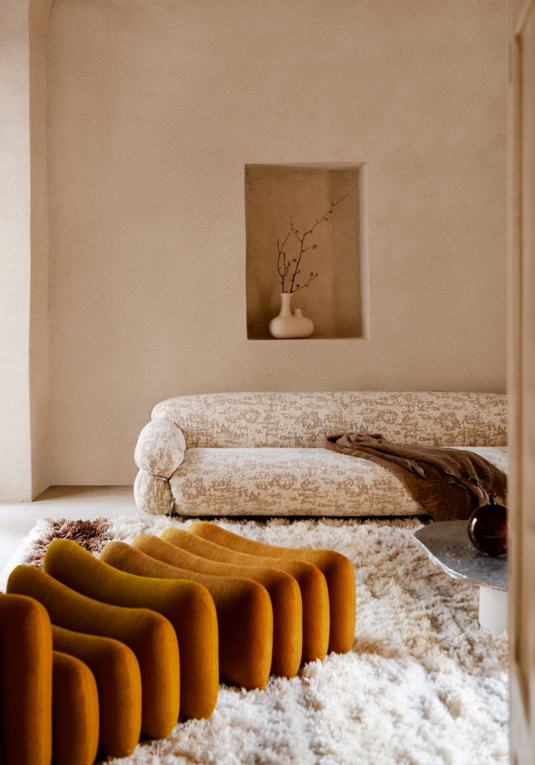A textured cream sofa sits on a plush rug with mustard yellow seating in a minimalist room.