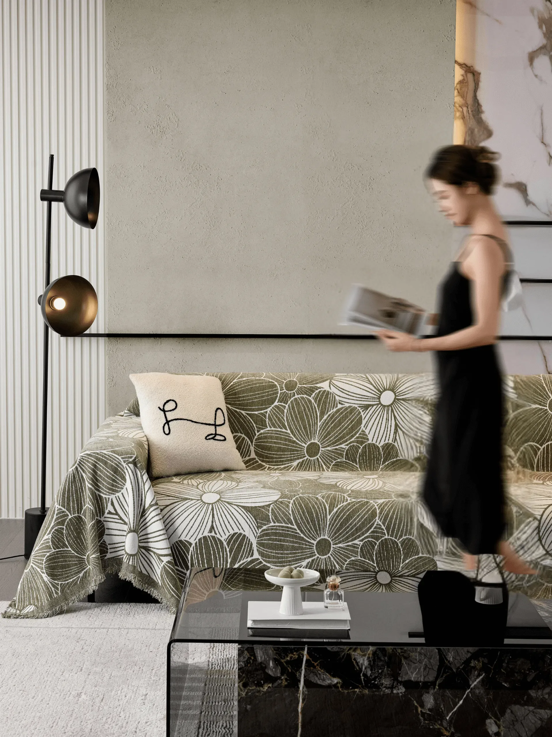 A woman walks past a floral-covered sofa in a modern living room with a floor lamp.